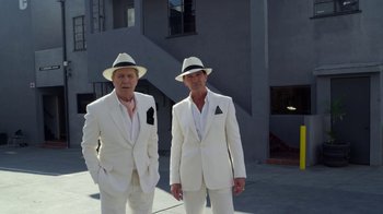Movie still from “The Laundromat” (2019), directed by Steven Soderbergh – A couple of men standing next to each other wearing suits; Wide shot, Low angle