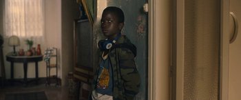 Movie still from “The Life Ahead” (2020), directed by Edoardo Ponti – A young boy wearing headphones and a jacket; Medium shot, Over the shoulder angle