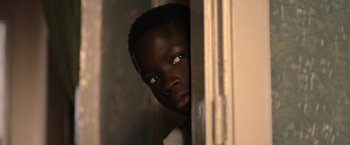 Movie still from “The Life Ahead” (2020), directed by Edoardo Ponti – A young man with a serious look on his face looking out a window; Close Up shot, Over the shoulder angle