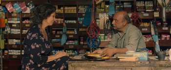 Movie still from “The Life Ahead” (2020), directed by Edoardo Ponti – A man and a woman sitting at a table in a store; Medium shot, Over the shoulder angle