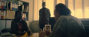 Movie still from “The Life Ahead” (2020), directed by Edoardo Ponti – A man standing in front of two other men; Medium shot, Over the shoulder angle