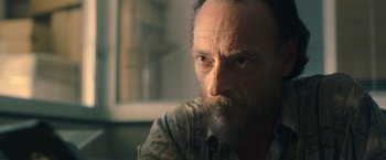 Movie still from “The Life Ahead” (2020), directed by Edoardo Ponti – A person with a beard looking at the camera; Close Up shot, Low angle