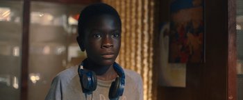 Movie still from “The Life Ahead” (2020), directed by Edoardo Ponti – A young boy wearing headphones and looking into the distance; Close Up shot, Over the shoulder angle