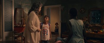 Movie still from “The Life Ahead” (2020), directed by Edoardo Ponti – A group of people standing around a room; Medium shot, Over the shoulder angle