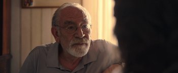 Movie still from “The Life Ahead” (2020), directed by Edoardo Ponti – An older man with glasses is looking at the camera; Close Up shot, Over the shoulder angle