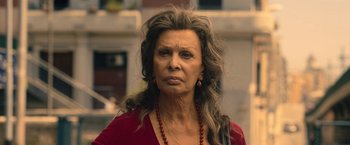 Movie still from “The Life Ahead” (2020), directed by Edoardo Ponti – An older woman with long gray hair wearing a red shirt; Close Up shot, Over the shoulder angle