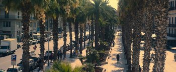 Movie still from “The Life Ahead” (2020), directed by Edoardo Ponti – People walking down a sidewalk lined with palm trees; Extreme Wide shot, High angle