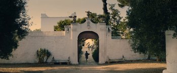 Movie still from “The Life Ahead” (2020), directed by Edoardo Ponti – A person walking down a path through an archway; Extreme Wide shot, Low angle