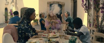 Movie still from “The Life Ahead” (2020), directed by Edoardo Ponti – A group of people sitting around a table with food; Medium shot, Low angle