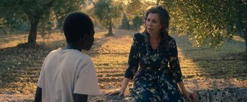 Movie still from “The Life Ahead” (2020), directed by Edoardo Ponti – An older woman talking to a young boy in a field; Medium shot, Over the shoulder angle