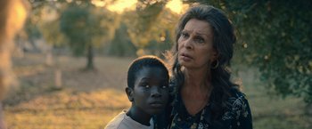 Movie still from “The Life Ahead” (2020), directed by Edoardo Ponti – An older woman and a young boy standing next to each other in a park; Close Up shot, Over the shoulder angle