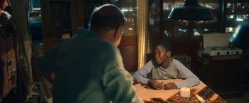 Movie still from “The Life Ahead” (2020), directed by Edoardo Ponti – A man sitting at a table with a young boy; Medium shot, Over the shoulder angle