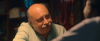 Movie still from “The Life Ahead” (2020), directed by Edoardo Ponti – An older man with a mustache is sitting in a room; Close Up shot, Over the shoulder angle