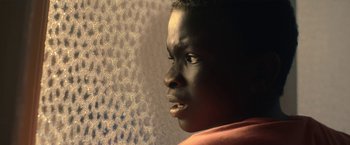 Movie still from “The Life Ahead” (2020), directed by Edoardo Ponti – A person looking out of a window; Close Up shot, Low angle