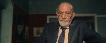 Movie still from “The Life Ahead” (2020), directed by Edoardo Ponti – An older man wearing a suit and tie; Close Up shot, Over the shoulder angle