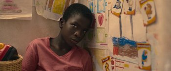 Movie still from “The Life Ahead” (2020), directed by Edoardo Ponti – A young boy standing in front of a wall covered in stickers; Close Up shot, Over the shoulder angle