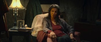 Movie still from “The Life Ahead” (2020), directed by Edoardo Ponti – An older woman sitting in a chair in a living room; Medium shot, High angle