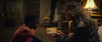 Movie still from “The Life Ahead” (2020), directed by Edoardo Ponti – An older man showing a young boy a picture; Medium shot, Over the shoulder angle