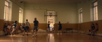 Movie still from “The Life Ahead” (2020), directed by Edoardo Ponti – A group of young men playing basketball in a gym; Wide shot, Low angle
