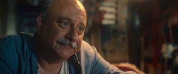 Movie still from “The Life Ahead” (2020), directed by Edoardo Ponti – An older man with a mustache is sitting in a room; Close Up shot, Low angle