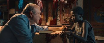 Movie still from “The Life Ahead” (2020), directed by Edoardo Ponti – A man sitting on a couch talking to a young man; Medium shot, Over the shoulder angle