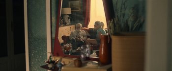 Movie still from “The Life Ahead” (2020), directed by Edoardo Ponti – An older man sitting on a couch next to an older woman; Wide shot, Over the shoulder angle