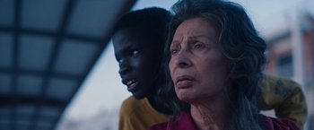 Movie still from “The Life Ahead” (2020), directed by Edoardo Ponti – An older woman and a younger man looking at the camera; Close Up shot, Over the shoulder angle