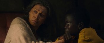 Movie still from “The Life Ahead” (2020), directed by Edoardo Ponti – An older woman and a young boy looking at each other in the dark; Close Up shot, Over the shoulder angle