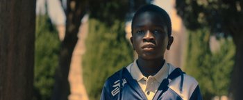 Movie still from “The Life Ahead” (2020), directed by Edoardo Ponti – A young boy is standing in front of a tree; Close Up shot, Low angle