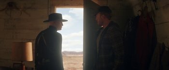 Movie still from “The Man from Toronto” (2022), directed by Patrick Hughes – Two men standing next to each other near a window; Medium shot, Over the shoulder angle