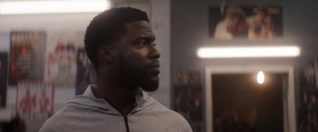 Movie still from “The Man from Toronto” (2022), directed by Patrick Hughes – A man standing in a room looking up at the ceiling; Close Up shot, Over the shoulder angle