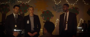 Movie still from “The Man from Toronto” (2022), directed by Patrick Hughes – A group of people standing next to each other in a room; Medium shot, Over the shoulder angle