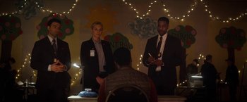 Movie still from “The Man from Toronto” (2022), directed by Patrick Hughes – A couple of people standing in front of a table; Medium shot, Over the shoulder angle