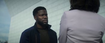 Movie still from “The Man from Toronto” (2022), directed by Patrick Hughes – A person standing next to another person; Close Up shot, Over the shoulder angle