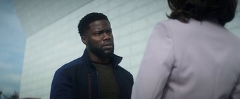 Movie still from “The Man from Toronto” (2022), directed by Patrick Hughes – A person standing next to another person; Close Up shot, Over the shoulder angle