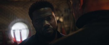 Movie still from “The Man from Toronto” (2022), directed by Patrick Hughes – A person with a beard looking at something; Close Up shot, Over the shoulder angle