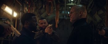 Movie still from “The Man from Toronto” (2022), directed by Patrick Hughes – A group of men standing next to each other in a room; Medium shot, Over the shoulder angle