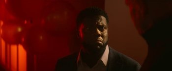 Movie still from “The Man from Toronto” (2022), directed by Patrick Hughes – A person wearing a suit and tie; Close Up shot, Low angle