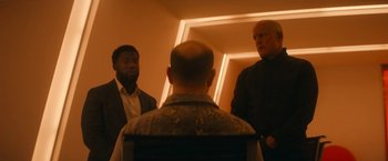 Movie still from “The Man from Toronto” (2022), directed by Patrick Hughes – A group of men standing next to each other in front of a mirror; Medium shot, Over the shoulder angle