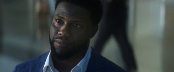 Movie still from “The Man from Toronto” (2022), directed by Patrick Hughes – A person wearing a suit and tie; Close Up shot, Over the shoulder angle
