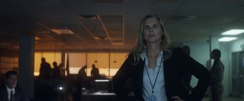 Movie still from “The Man from Toronto” (2022), directed by Patrick Hughes – A woman standing in an office with a camera in her hand; Medium shot, Low angle