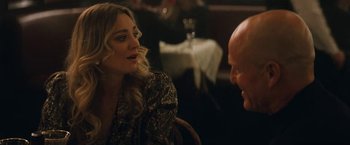 Movie still from “The Man from Toronto” (2022), directed by Patrick Hughes – A woman sitting next to a man in a restaurant; Medium shot, Over the shoulder angle