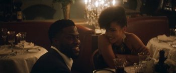 Movie still from “The Man from Toronto” (2022), directed by Patrick Hughes – A man and a woman sitting at a dinner table; Medium shot, Over the shoulder angle