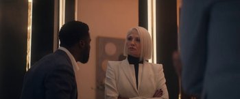 Movie still from “The Man from Toronto” (2022), directed by Patrick Hughes – A man and a woman standing next to each other in a room; Medium shot, Over the shoulder angle