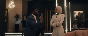 Movie still from “The Man from Toronto” (2022), directed by Patrick Hughes – A man and a woman are standing next to each other; Medium shot, Over the shoulder angle