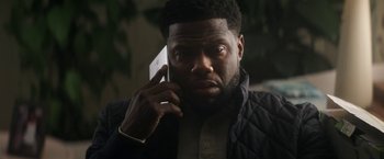 Movie still from “The Man from Toronto” (2022), directed by Patrick Hughes – A person talking on a cell phone; Close Up shot, Over the shoulder angle