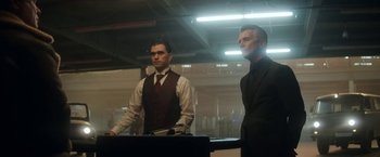 Movie still from “The Man from Toronto” (2022), directed by Patrick Hughes – Two men standing next to each other in a room; Medium shot, Low angle