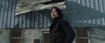 Movie still from “The Man from Toronto” (2022), directed by Patrick Hughes – A person standing in front of an old building; Medium shot, Low angle