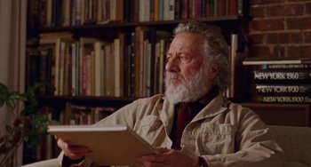 Movie still from “The Meyerowitz Stories” (2017), directed by Noah Baumbach – An older man sitting in front of a book shelf; Close Up shot, Low angle