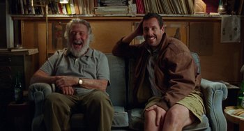 Movie still from “The Meyerowitz Stories” (2017), directed by Noah Baumbach – Two men sitting on a couch smiling for the camera; Medium shot, Low angle